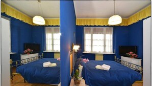 A mirrored room with two beds, a small table with a lamp, and a window with curtains. - Osteria Gaute La Nata (Viu)