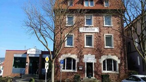 Een hotel met een bord waarop 'ADLERHOEF HOTEL' staat en een parkeersbord in de buurt.