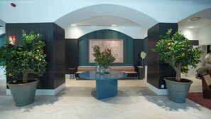 Relax in the elegant lobby, surrounded by lush greenery and a stunning map display.