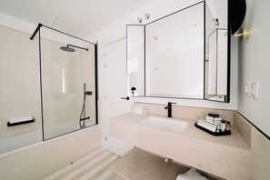 Enjoy a refreshing shower in the bathroom, featuring a glass-enclosed shower and separate sink with a faucet.