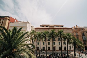 Stunning multi-story building with a traditional architectural style, set amidst lush palm trees in an urban setting.