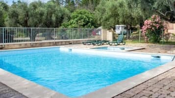 Una piscina al aire libre de temporada, sombrillas