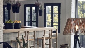 A modern kitchen with hanging planters, a wooden bar counter, and a wicker chair. - Skiathos Blu (Skiathos)