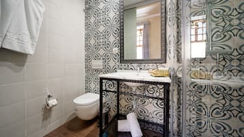 Un baño con inodoro, lavabo y zona de ducha.