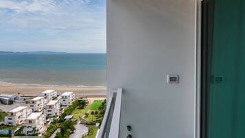 A balcony with a view of the beach and ocean.