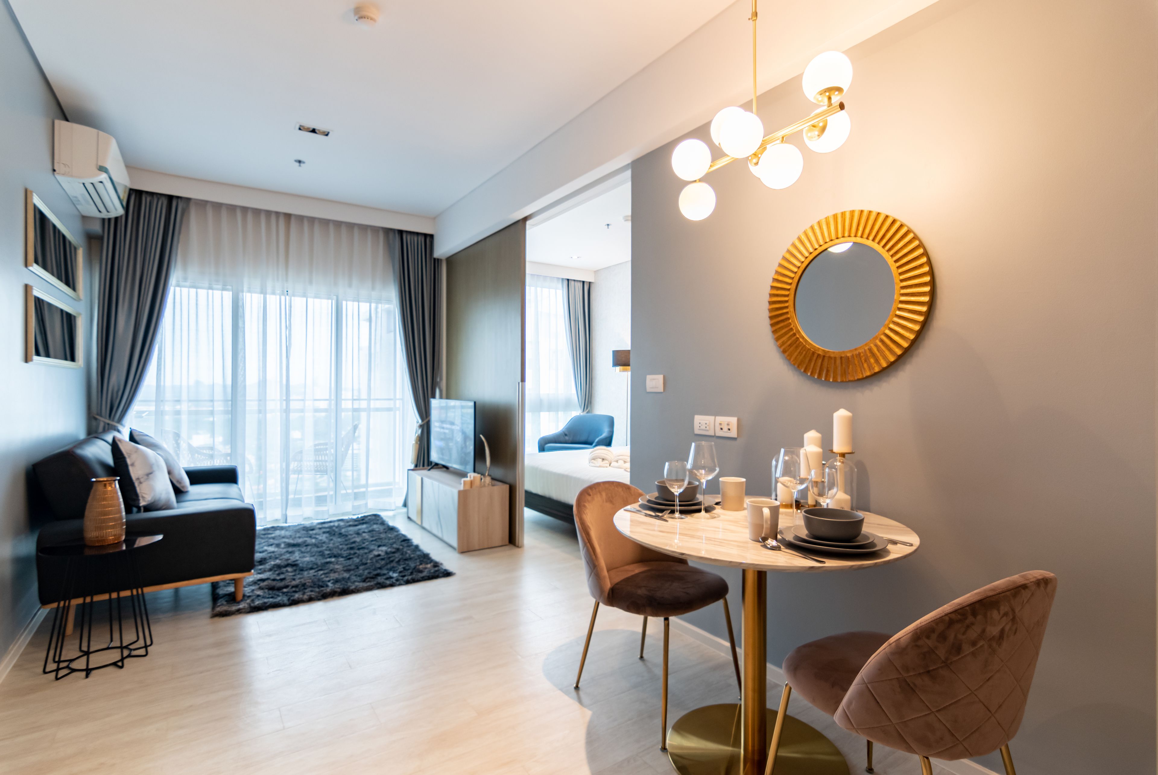 Een moderne hotelkamer met een eethoek, een bank en een televisie.