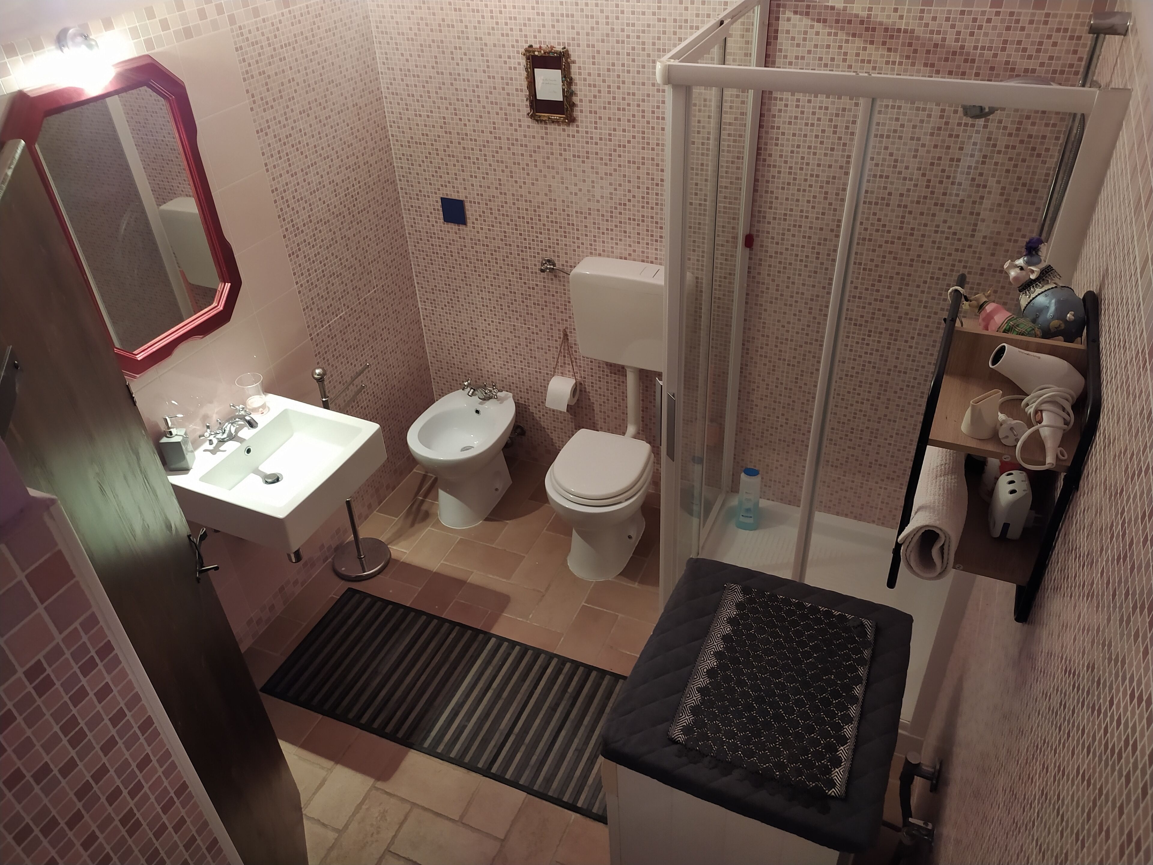 A bathroom with a sink, bidet, toilet, and shower.