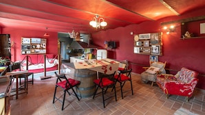 Un comedor acogedor con una mesa central, sillas y una pared roja decorada con cuadros.