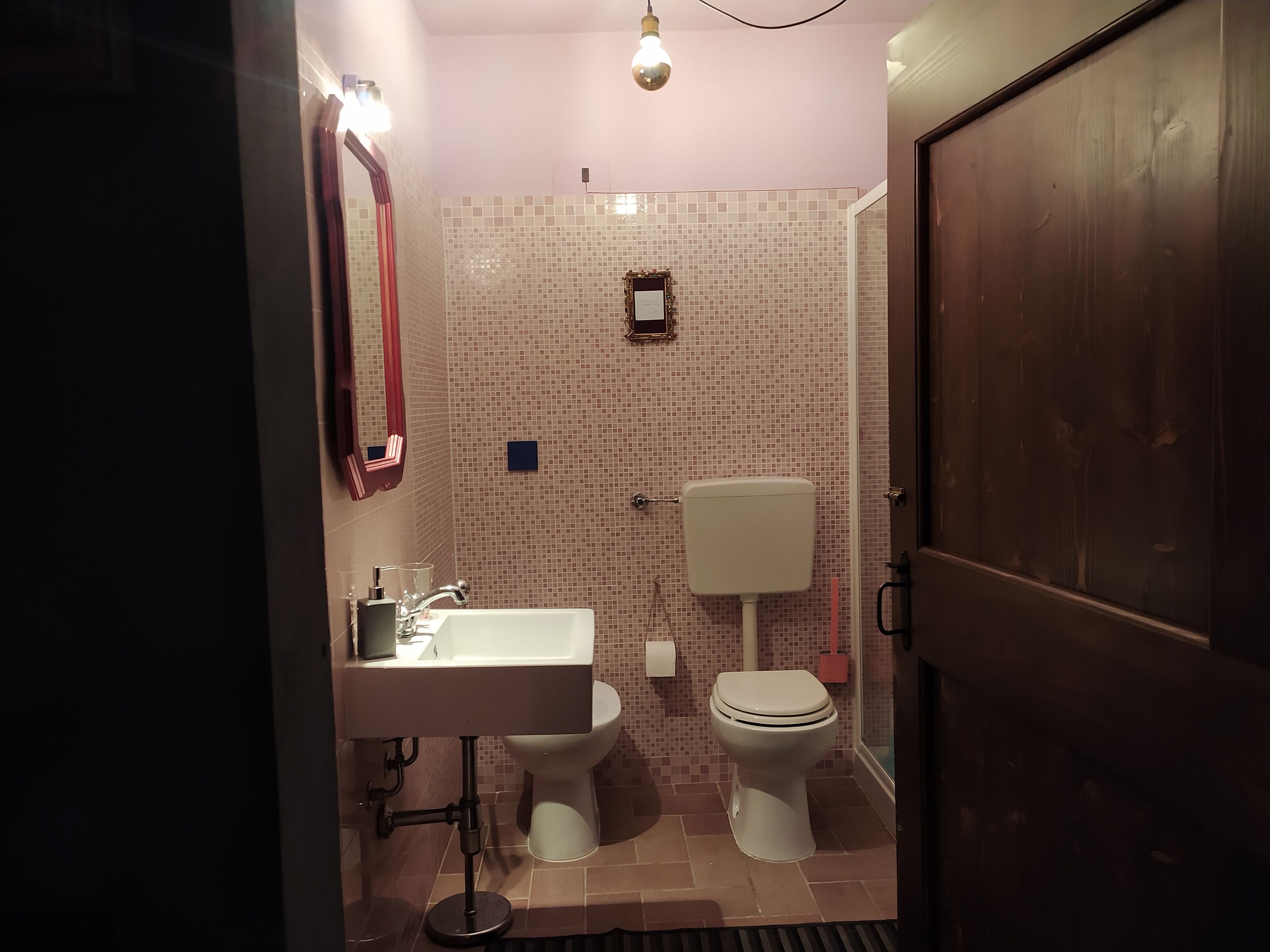 A bathroom with a white sink, a toilet, and a mirror.
