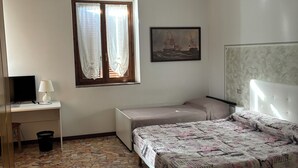 A bedroom with a bed, a desk, a chair, a window with curtains, a ceiling fan, and a wall-mounted air conditioner. - B&B Luna (Seriate)