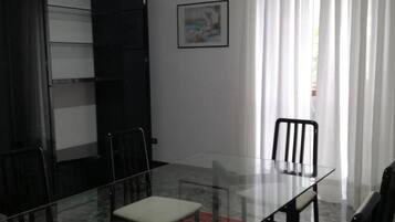 Une salle de conférence avec une table en verre, des chaises noires et un tapis rouge à motifs.