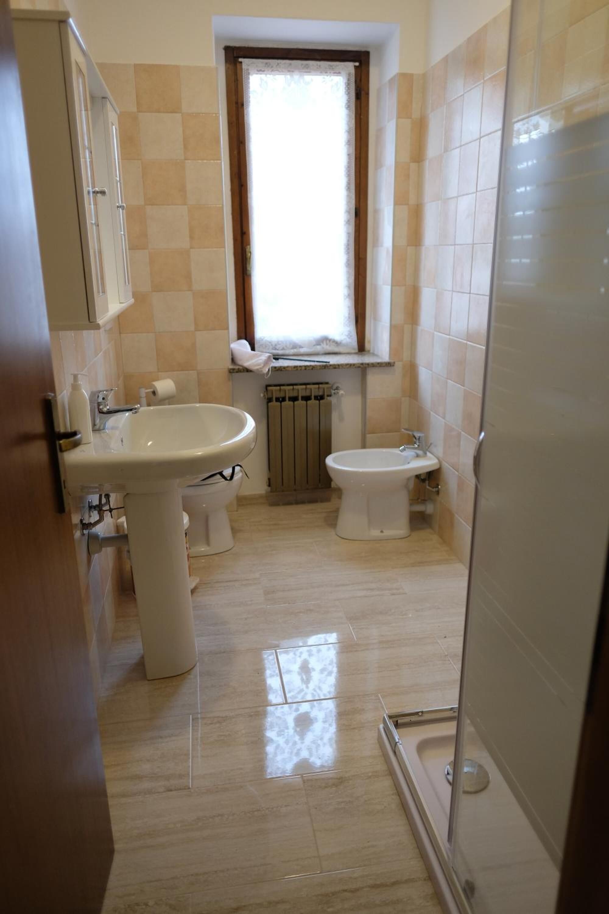 A bathroom with a sink, bidet, and toilet.