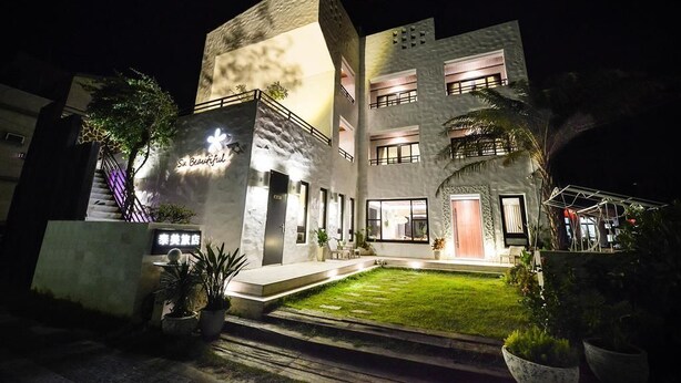 A modern hotel with a well-lit entrance, a small garden, and a sign that reads "Se Beautiful." - Su Beautiful Homestay (Liuqiu)