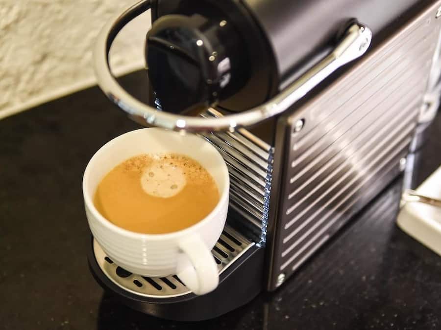 Eine Kaffeemaschine mit einer Kaffeetasse auf der Tropfschale.