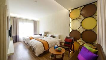 Una habitación de hotel con dos camas, un sofá, una mesita y un panel decorativo en la pared.