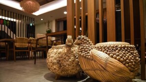 A room with a modern interior design, featuring a wooden floor, a sofa, and a decorative wall panel. - Su Beautiful Homestay (Liuqiu)