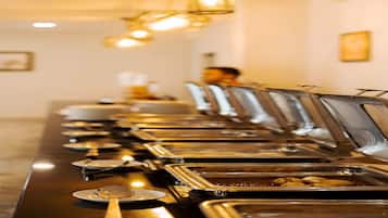 A buffet line with multiple food stations, each with a metal tray and a spoon.