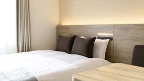 Une chambre d’hôtel comprenant un lit, une table de chevet et une tête de lit dotée d’un éclairage intégré.