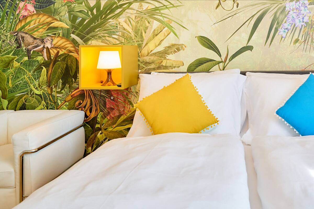 A bed with white bedding, two pillows, and two bedside lamps.