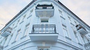 A white building with ornate balconies and a classical architectural style.