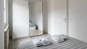 Een hotelkamer met een bed, een kledingkast en een spiegel.