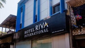 A building with a sign reading "HOTEL RIVA INTERNATIONAL". - Hotel Riva International - Near Nesco Center (Mumbai)