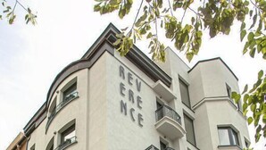 Un edificio de varios pisos con balcones y acceso por la planta baja.