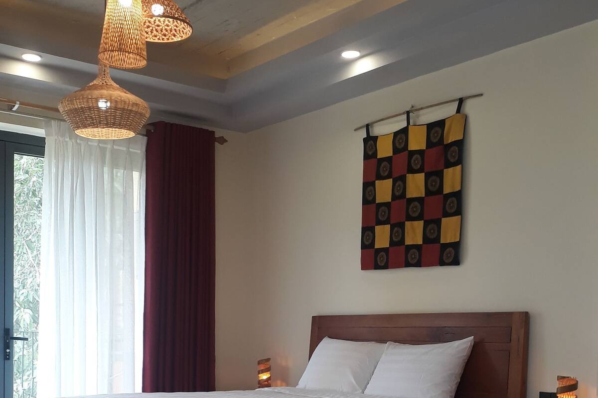 Une chambre à coucher comprenant un lit, une table de chevet, une lampe fixée au mur et un élément décoratif mural.