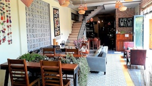 Comedor con mesa de madera, sillas y lámparas tejidas anaranjadas colgantes.