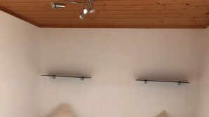 A room with two single beds, each with a pillow and a bedside table with a lamp. - Kleines Ferienhaus (Berlin)