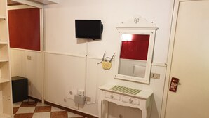 A hotel room with a checkered floor, a white vanity with a mirror, a television mounted on the wall, and a red door with a 'DO NOT DISTURB' sign. - Ca' del Sol Venezia (Venice)