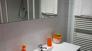 A bathroom with a white sink, a shower, and a towel rack. - Ca' del Sol Venezia (Venice)