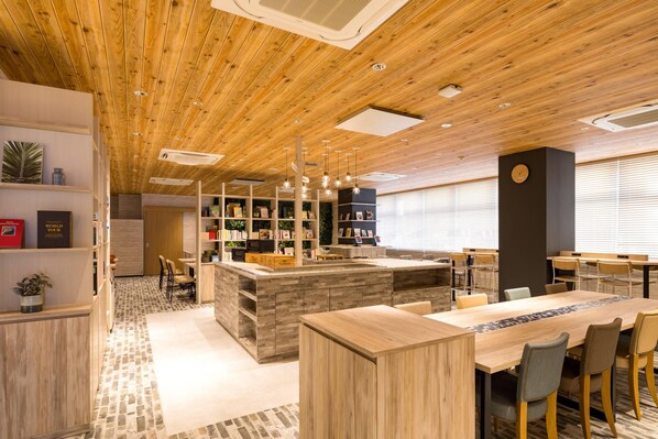 A modern interior with wooden ceiling, a central island with seating, and a bookshelf area.