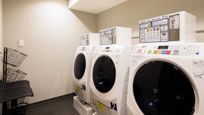 Un cuarto de lavandería con varias lavadoras y un tendedero.