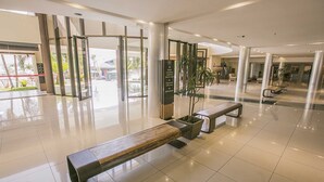 A spacious lobby with a wooden bench, a potted plant, and a clear view of the outside. - Life Resort Hplus Long Stay (Brasília)