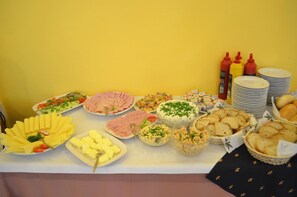 Uma mesa de buffet com diversos alimentos e acompanhamentos.