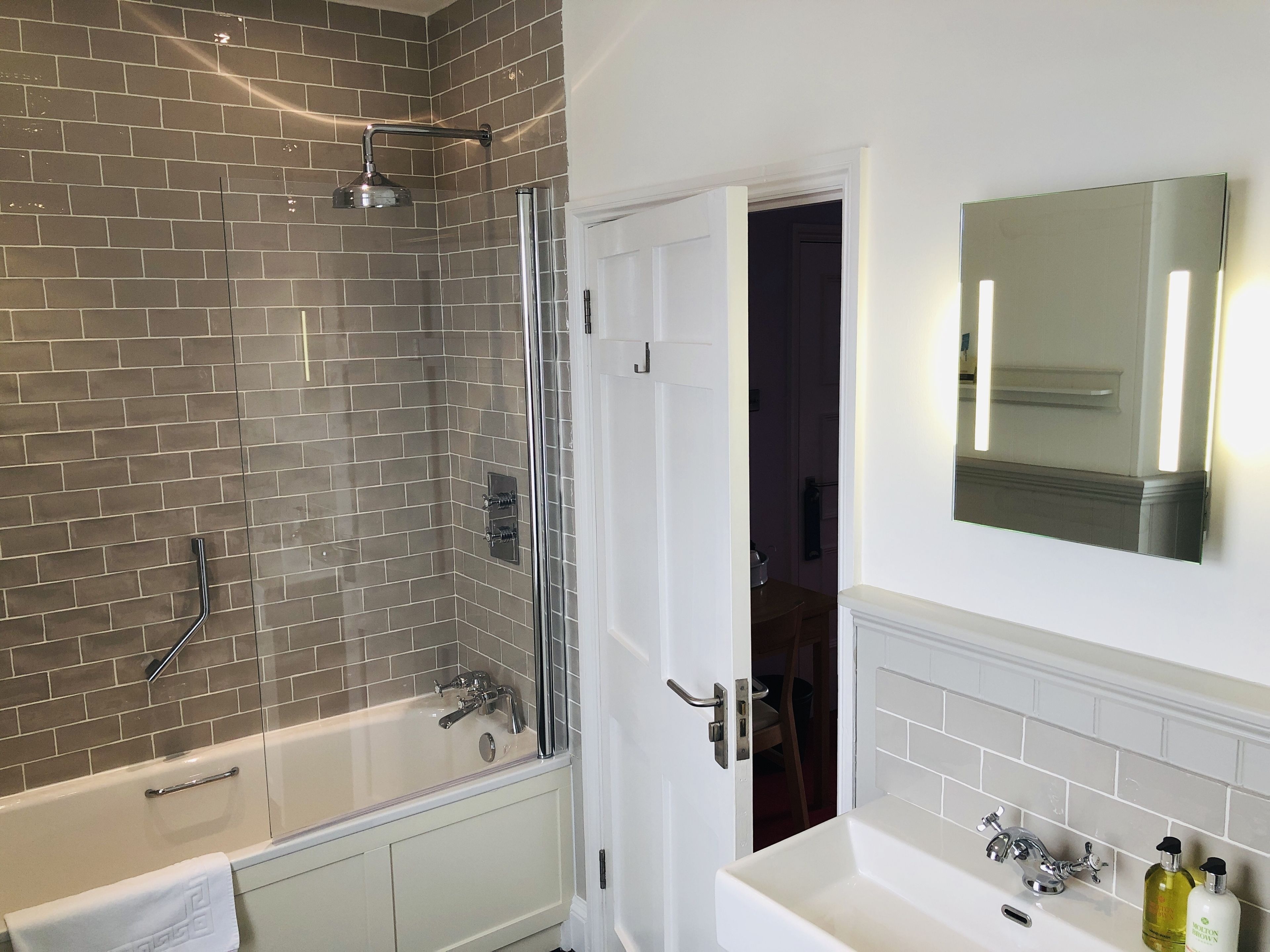 A bathroom with a bathtub, shower, and sink.