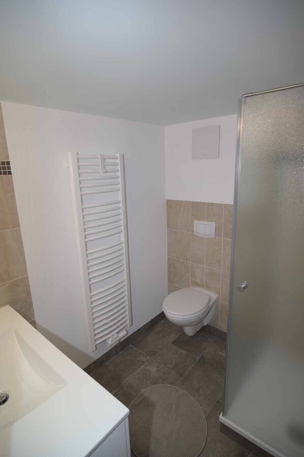 A bathroom with a bathtub, toilet, and a shower stall.