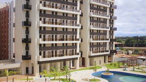 A multi-story residential building with balconies, a swimming pool, and a landscaped courtyard. - Venice Park Hplus Long Stay (Guará)