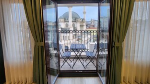 Un balcón con vistas a un edificio histórico y una torre.