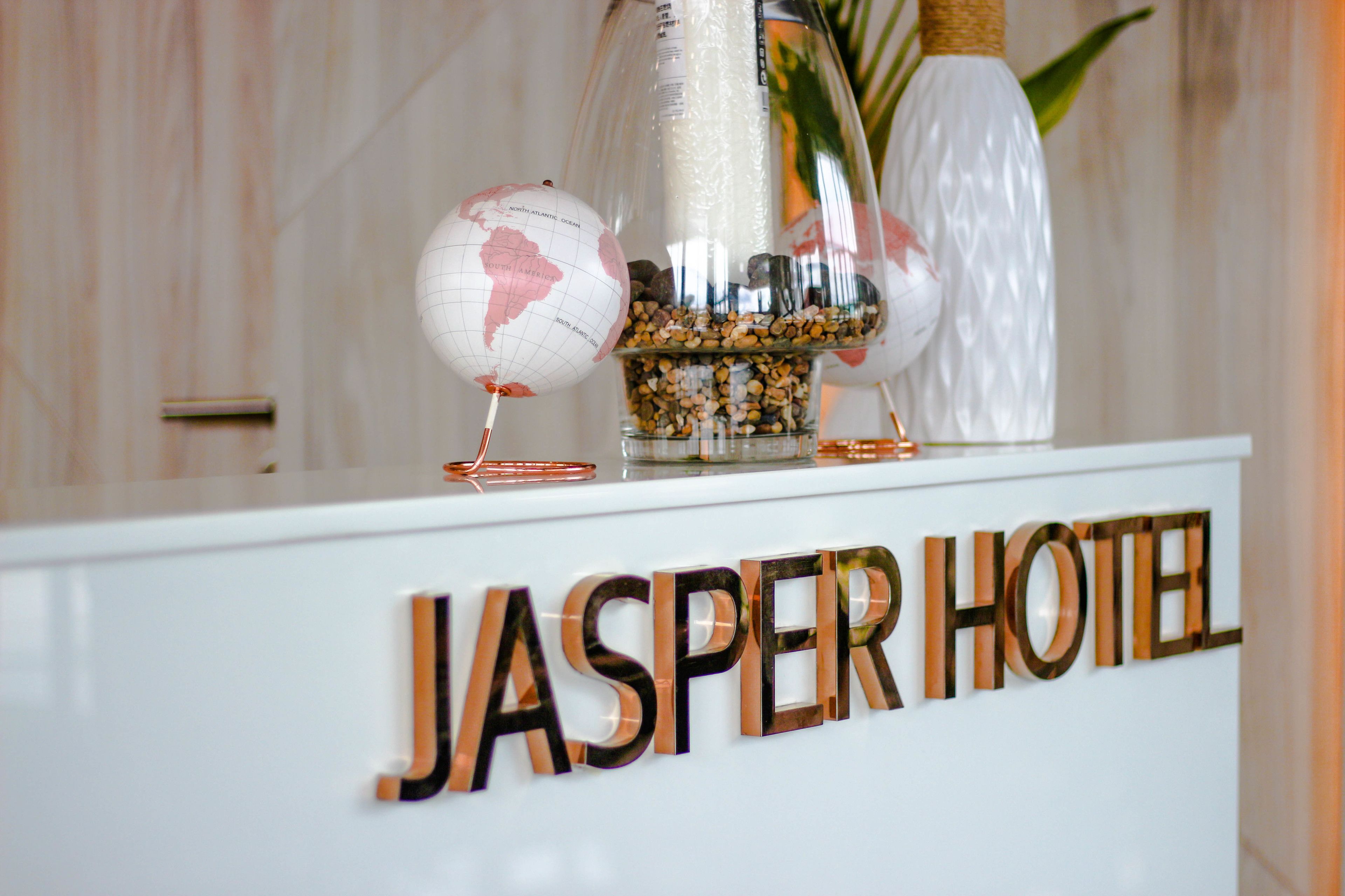 A reception desk with the name "JASPER HOTEL" in large letters.