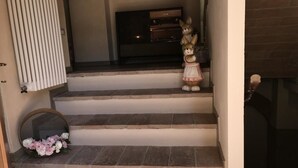 Una escalera con un descansillo pequeño, un espejo y una estatua decorativa de conejo.