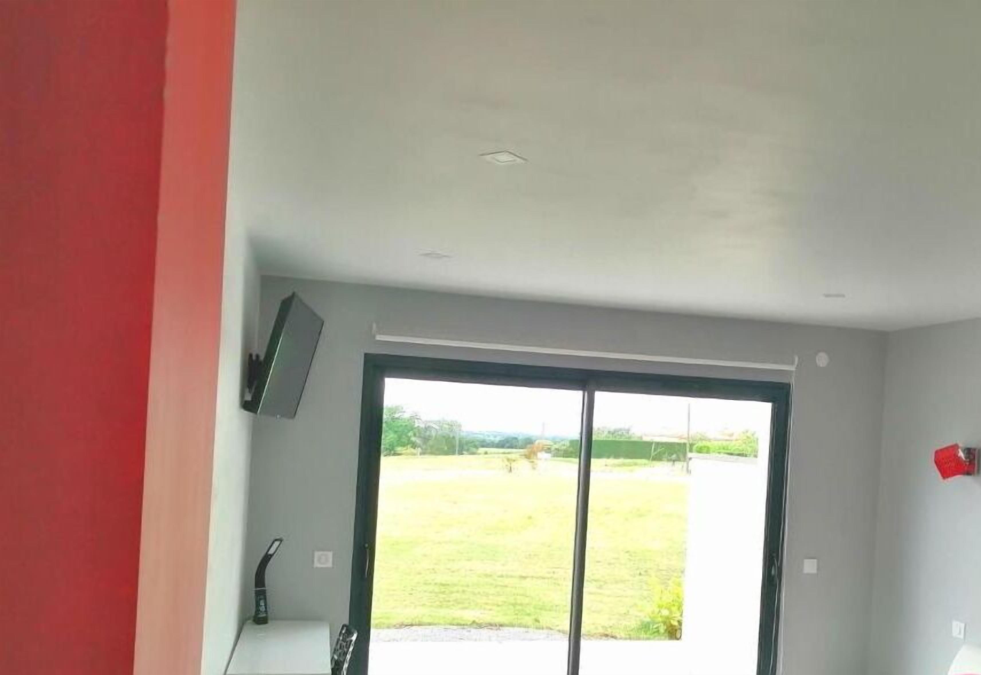 Quarto com uma grande porta de correr de vidro que dá para uma área externa gramada.