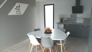 A modern kitchen with a dining area. - Le Temps d'un Reve (Eauze)