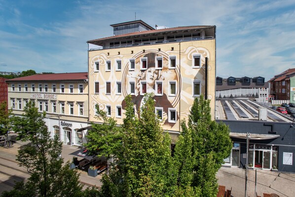 A building with a mural, a sign for 'HOTEL BÖRSE,' and a storefront named 'LONES.'