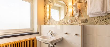 A bathroom with a sink, mirror, and towel rack.