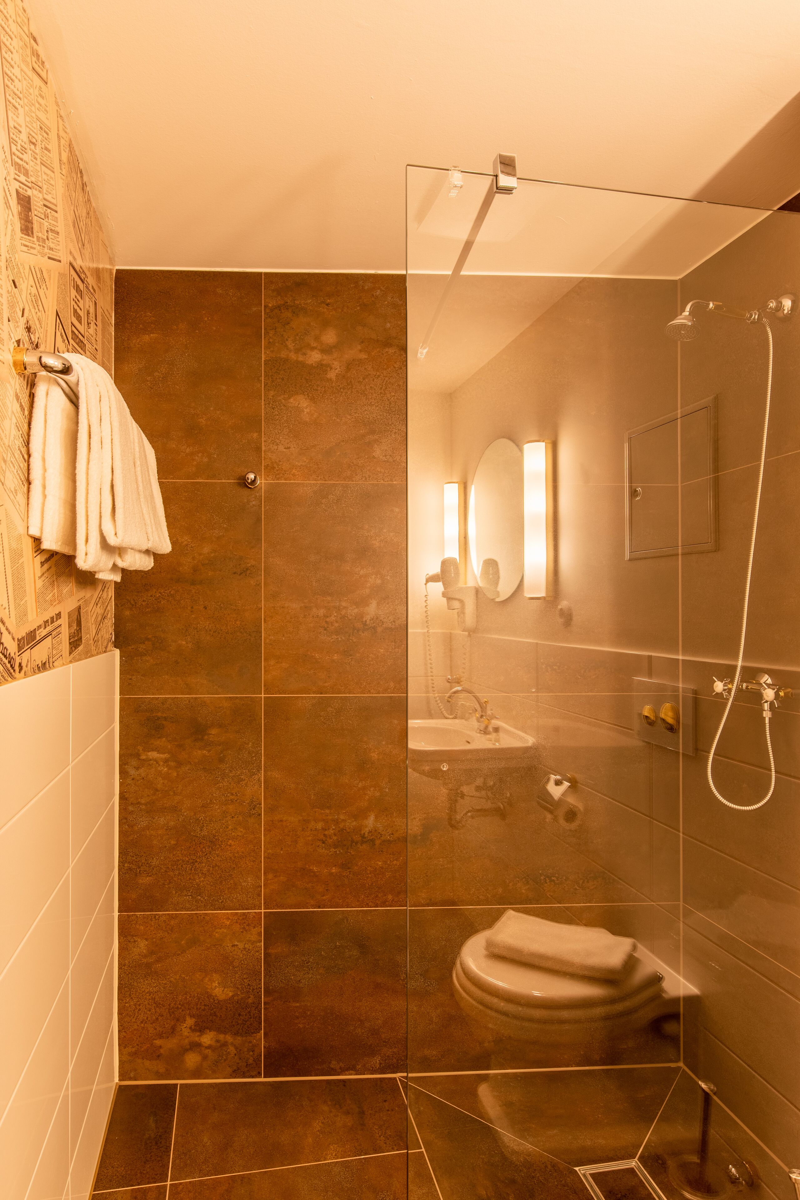 Un baño moderno con cabina de ducha de vidrio, inodoro y lavamanos.