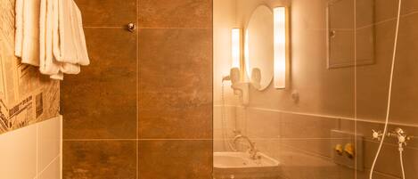 Un baño moderno con cabina de ducha de vidrio, inodoro y lavamanos.