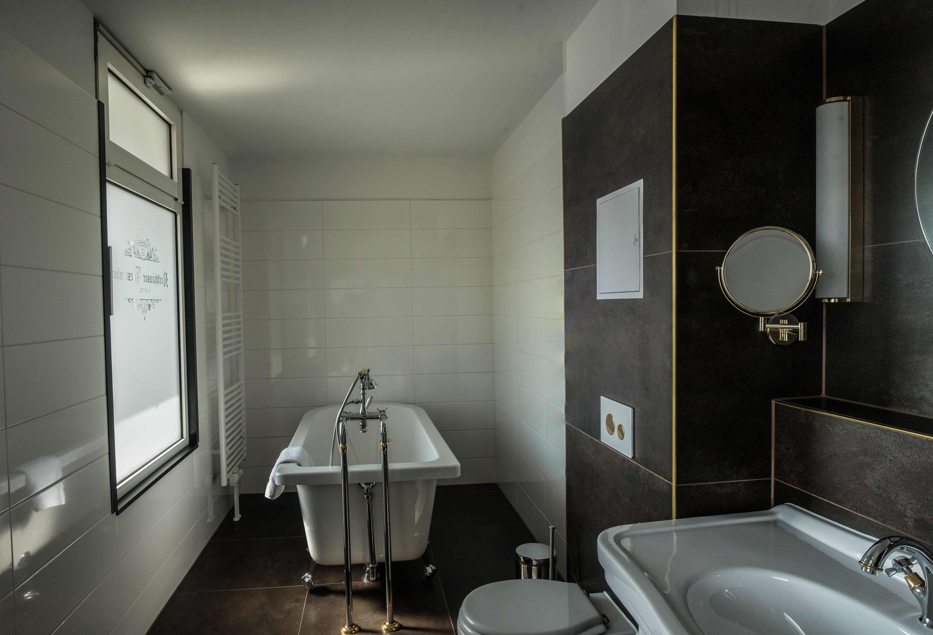 A modern bathroom with a bathtub, toilet, and sink.