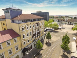 A building with a mural, a tram line, and a bus stop.